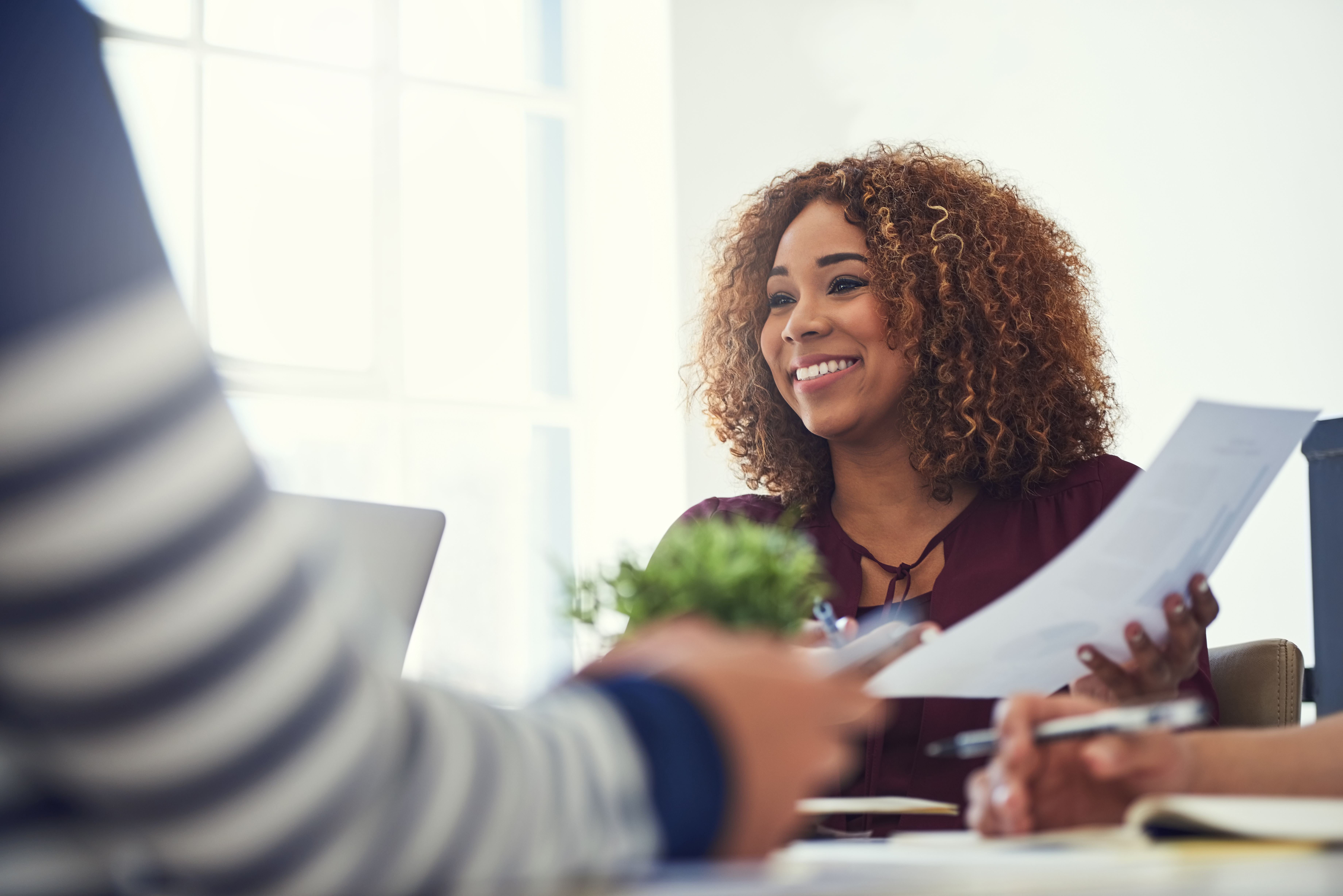 patient sitting down with his hands intertwined. There is a healthcare professional holding a tablet with a stylus