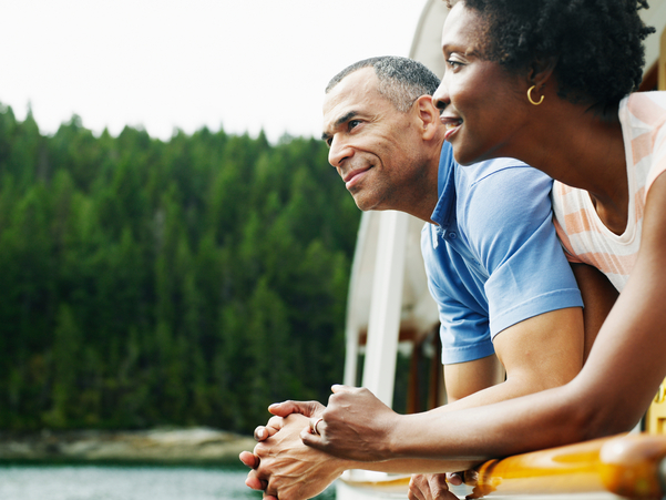 Couple bending on railing in nature