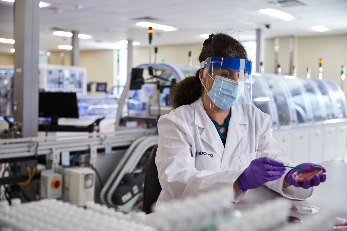 Scientist holding a pipette while extracting a specimen