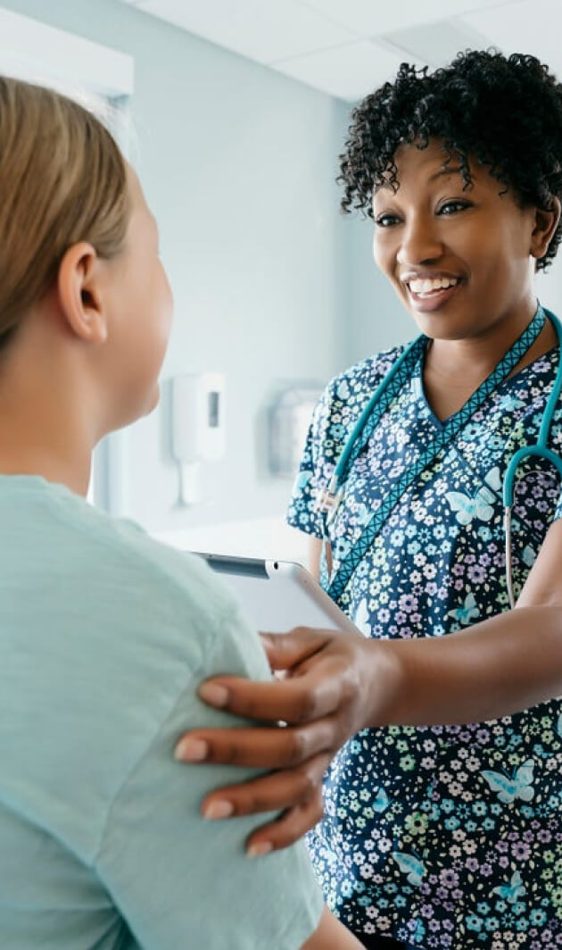 Provider in scrubs touching a patient's shoulder
