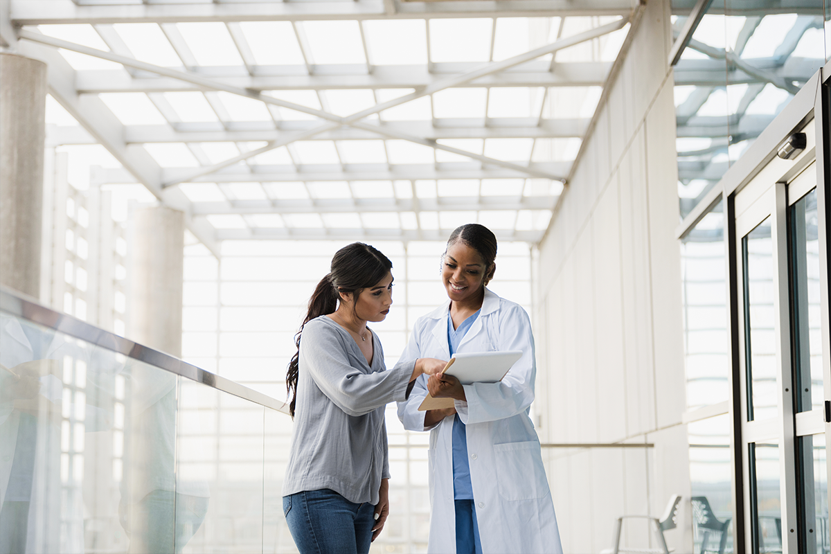 Provider talking to a patient in an annex. Patient is pointing at the chart